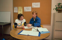 A volunteer working with a student in the Writing Centre