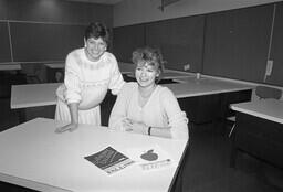 Two graphic design students pose with concepts for a Fraser Valley College continuing education Fall 1988 cover.