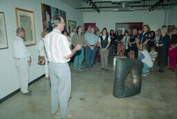 Opening event at UCFV art gallery. Dean Dick Bate is addressing the crowd. Art history professor Rory Wallace stands to left side.